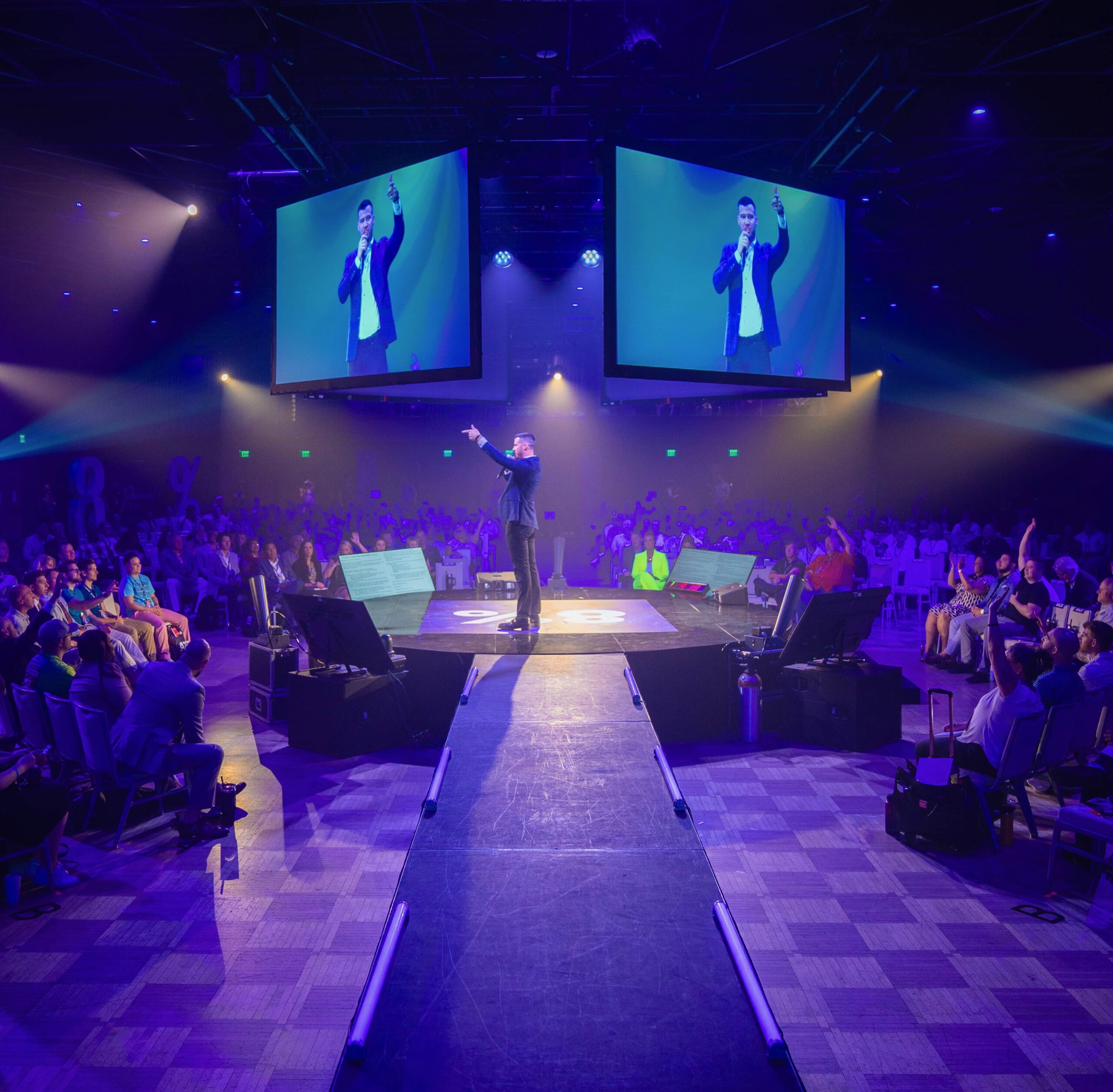 Cody Askins on stage at 8% Nation with full crowd and jumbotrons